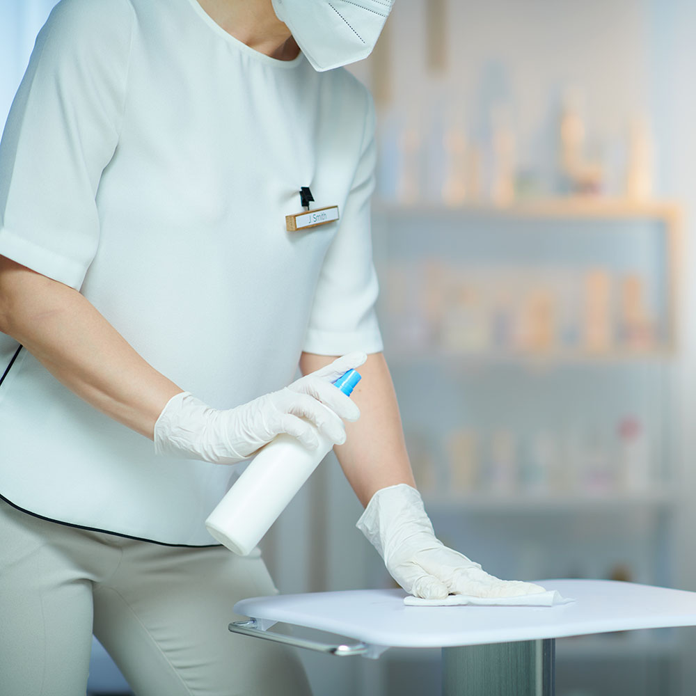  Woman with ffp2 mask and disinfectant in clinic